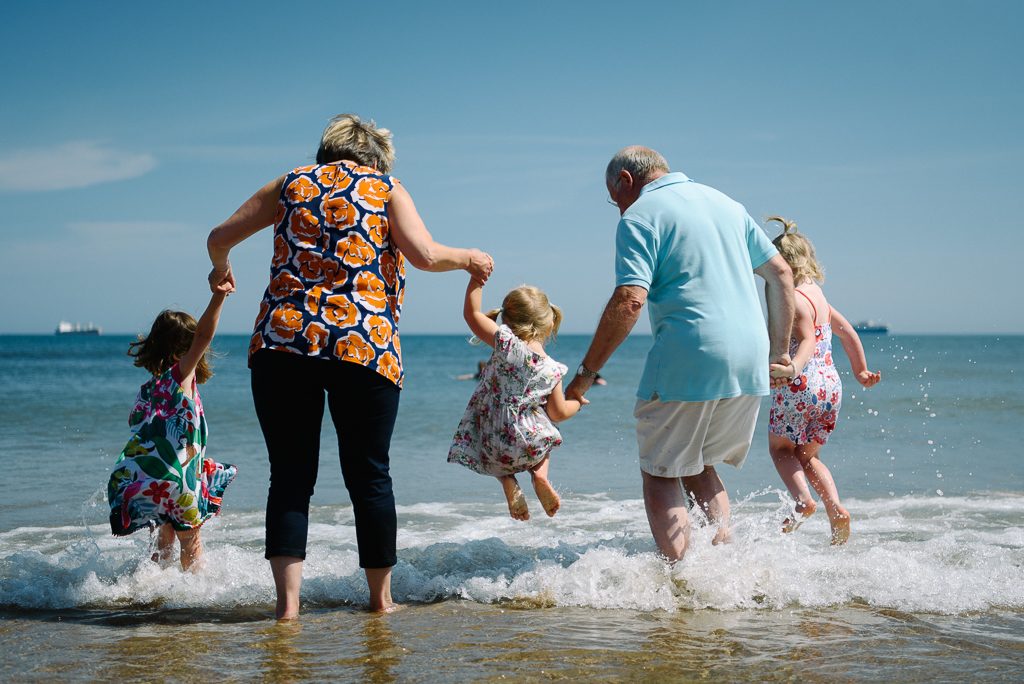 grandparents and children jumping in sea