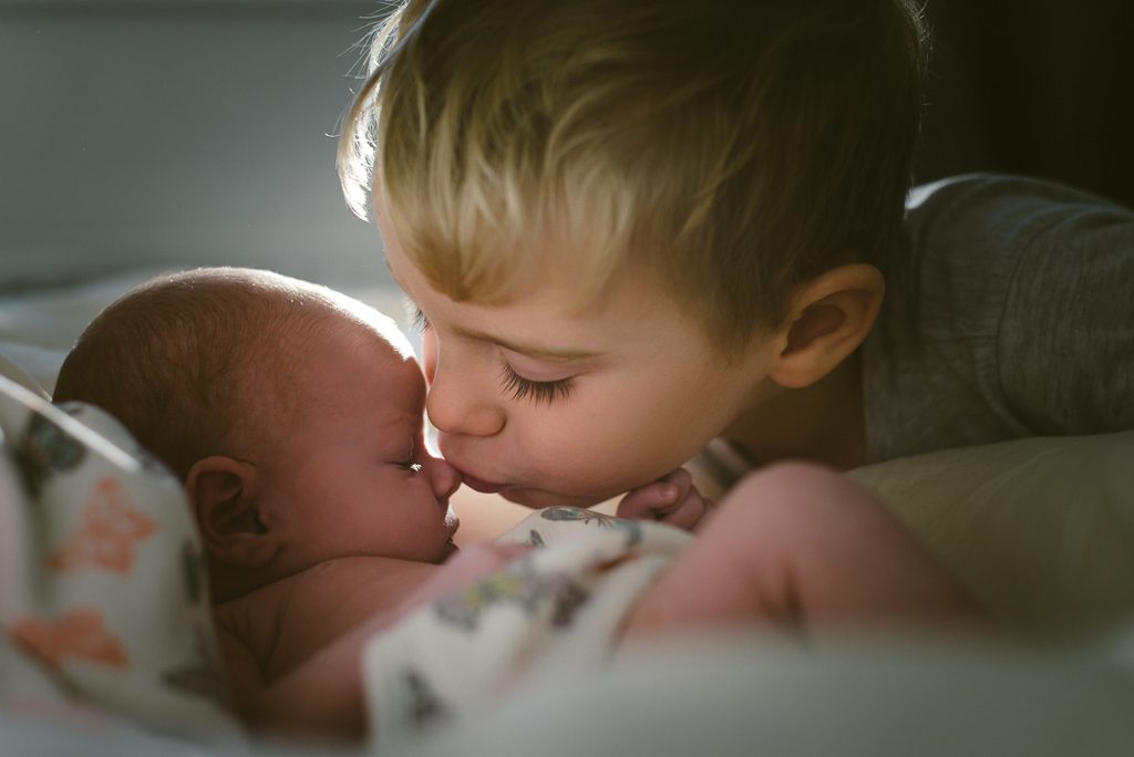 siblings kissing on bed