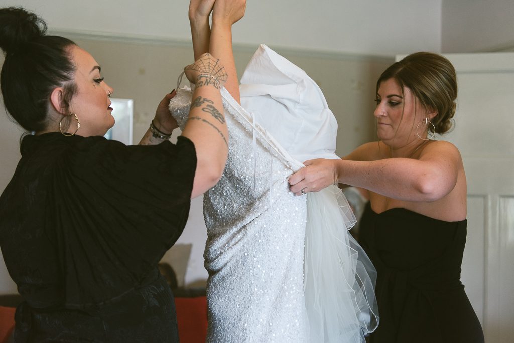 Using pillowcase to protect brides hair whilst putting on dress
