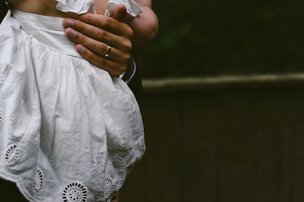 dad holding baby at wedding