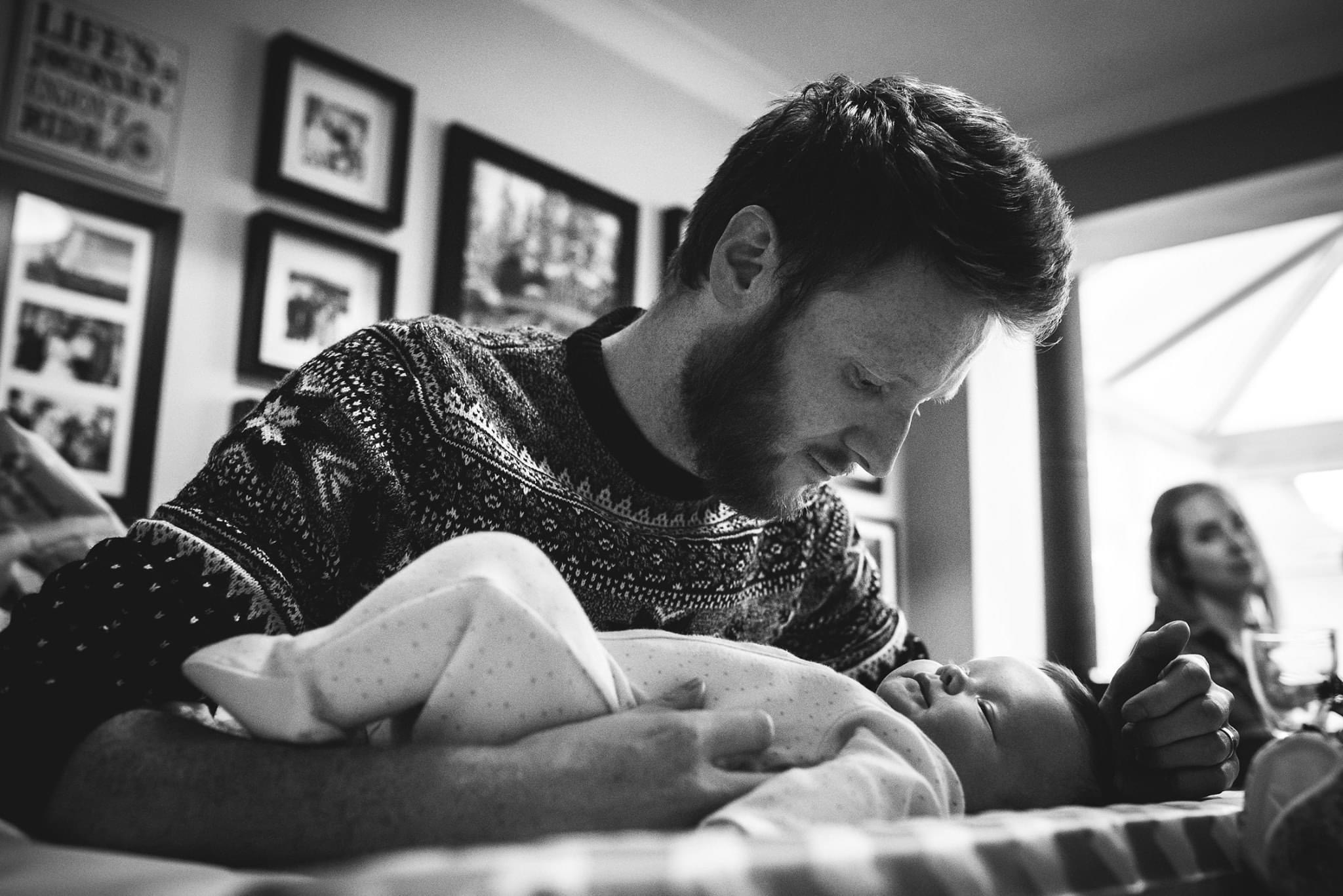 Dad cuddling newborn baby