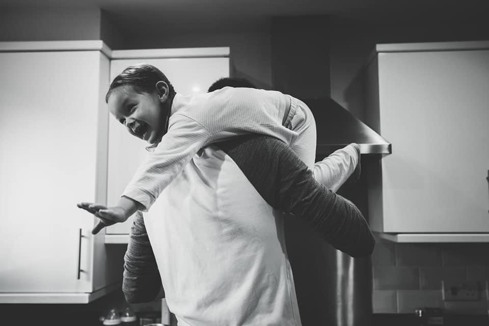 Daddy carries little girl on shoulder
