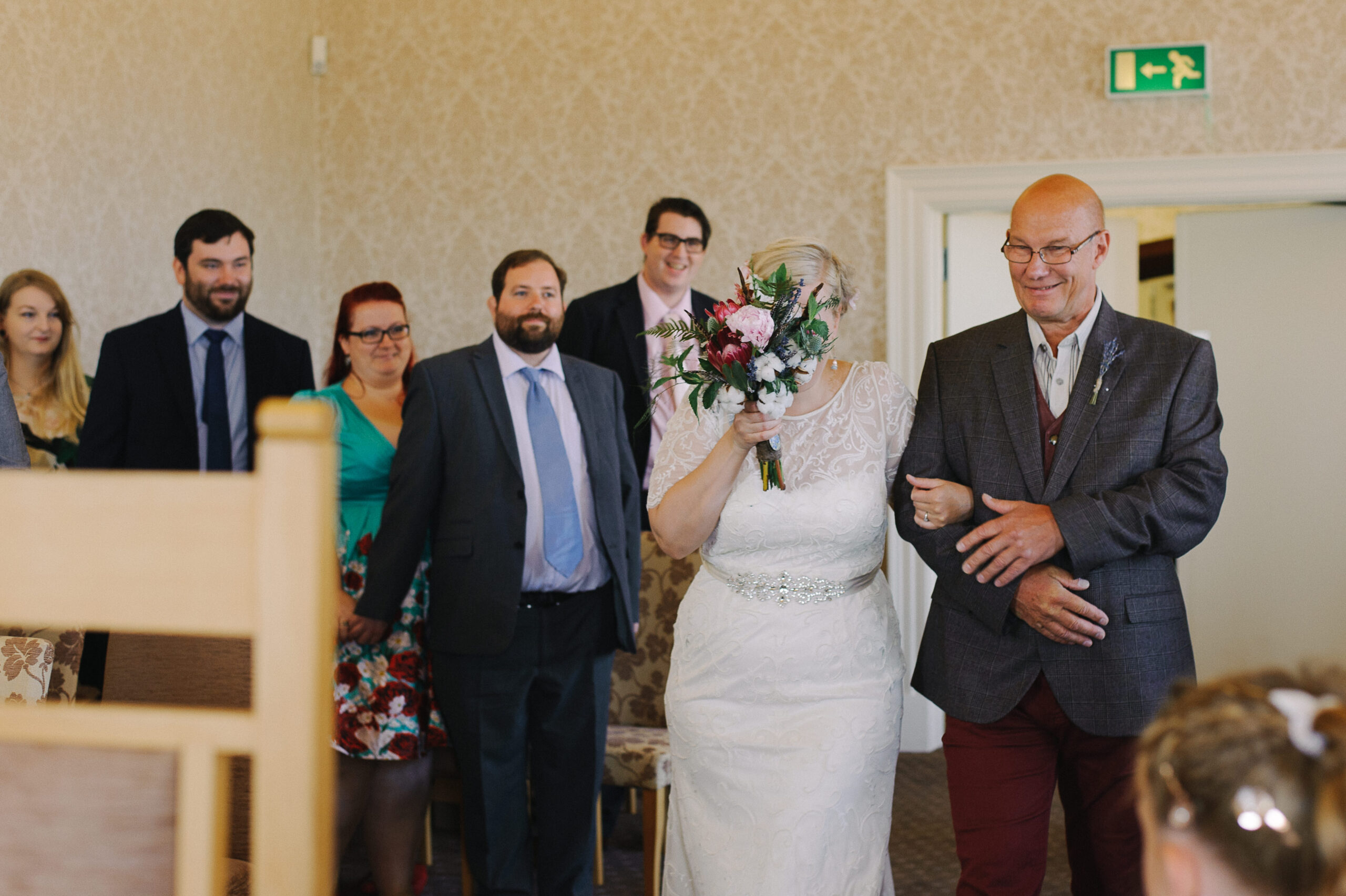 crying bride hiding behind bouquet