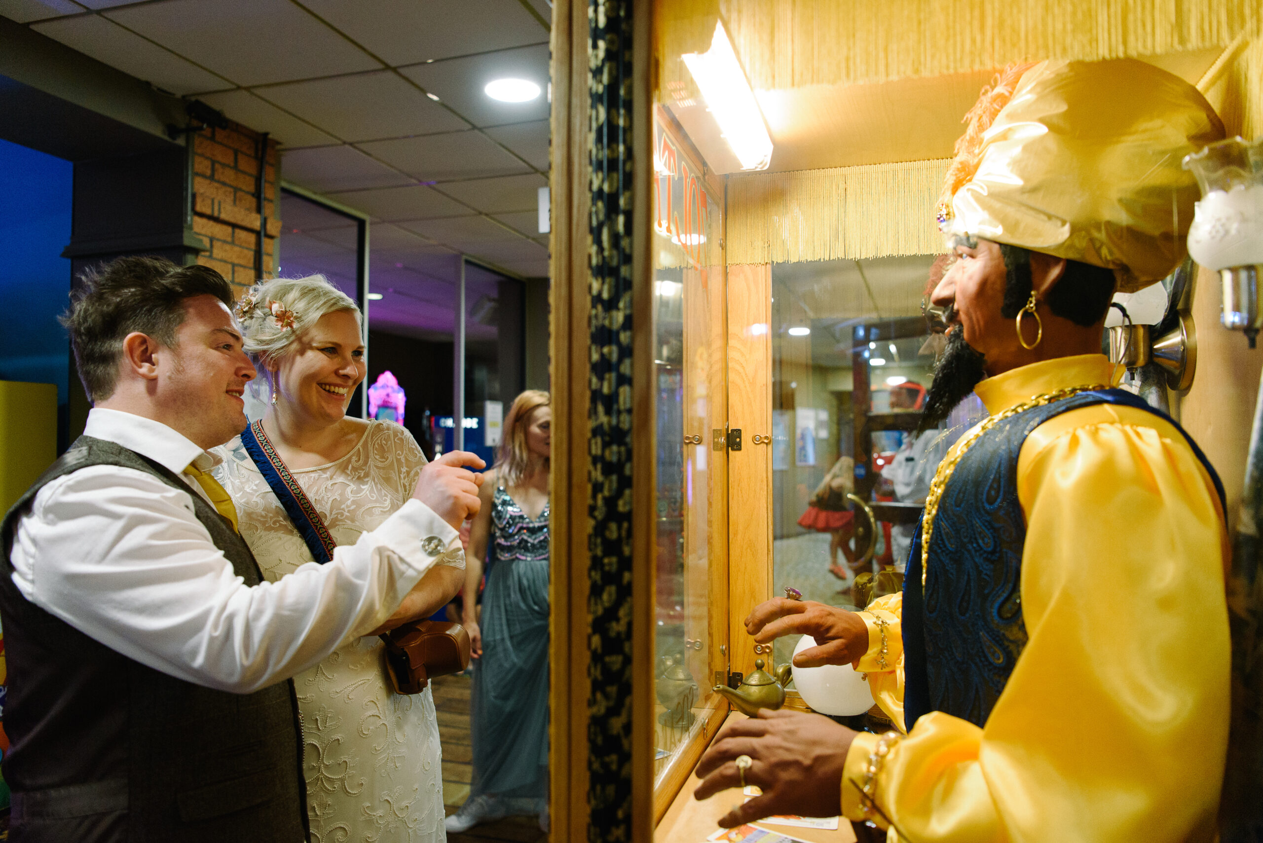 bride and groom playing with zoltar at ocean beach