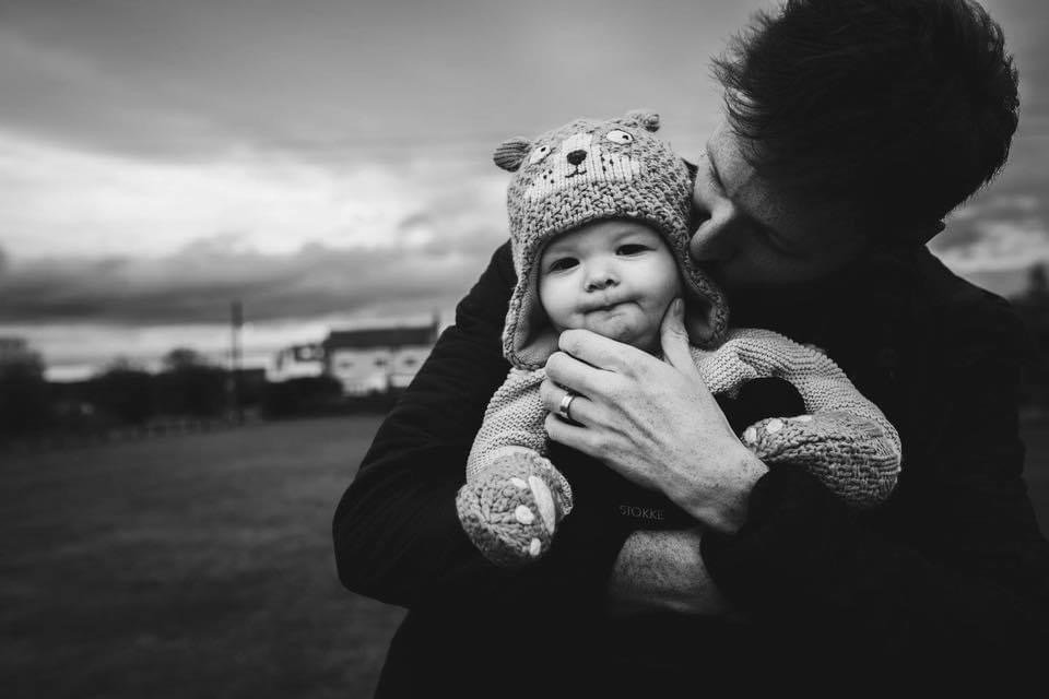 Daddy cuddles newborn