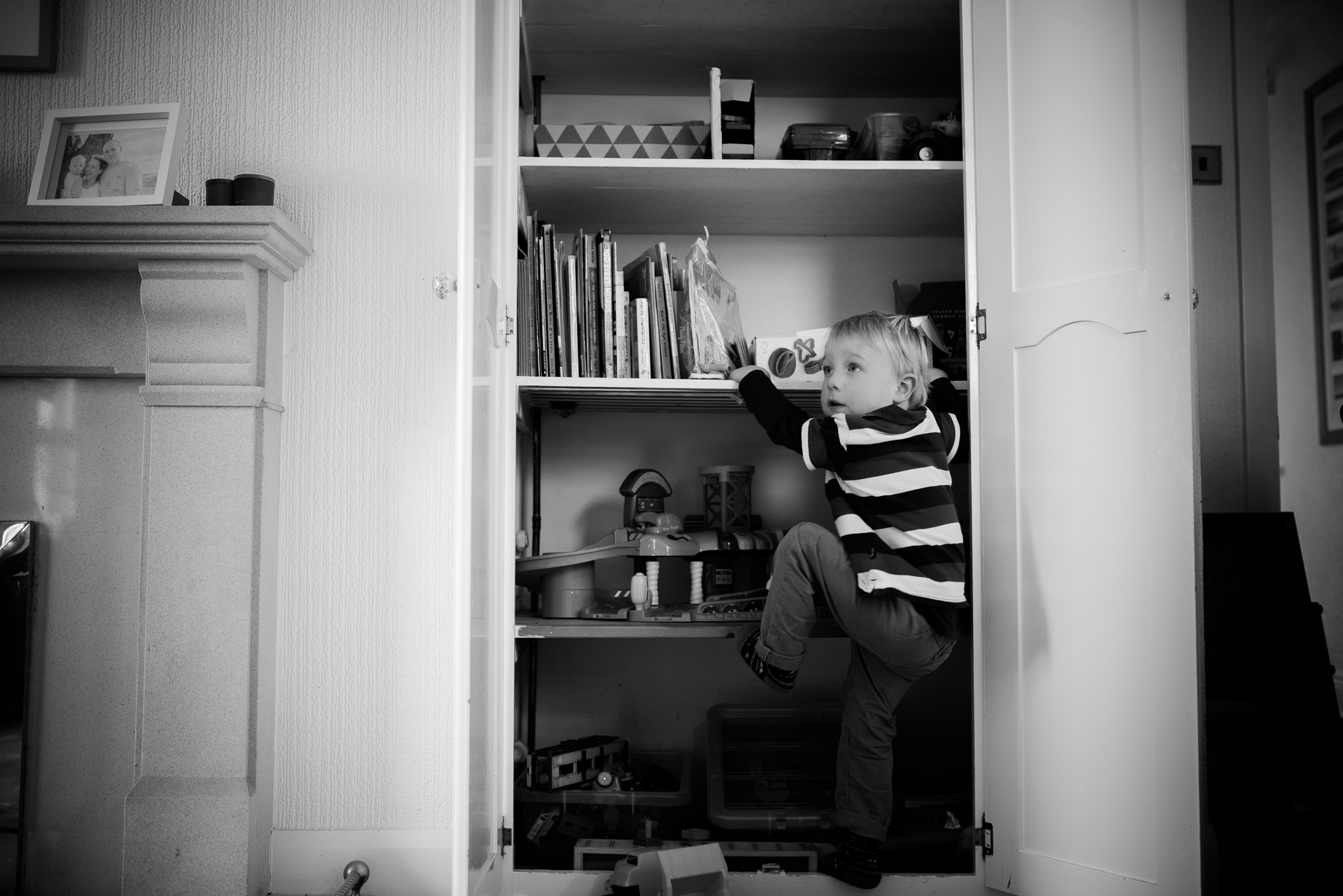 boy climbing into toy cupboard