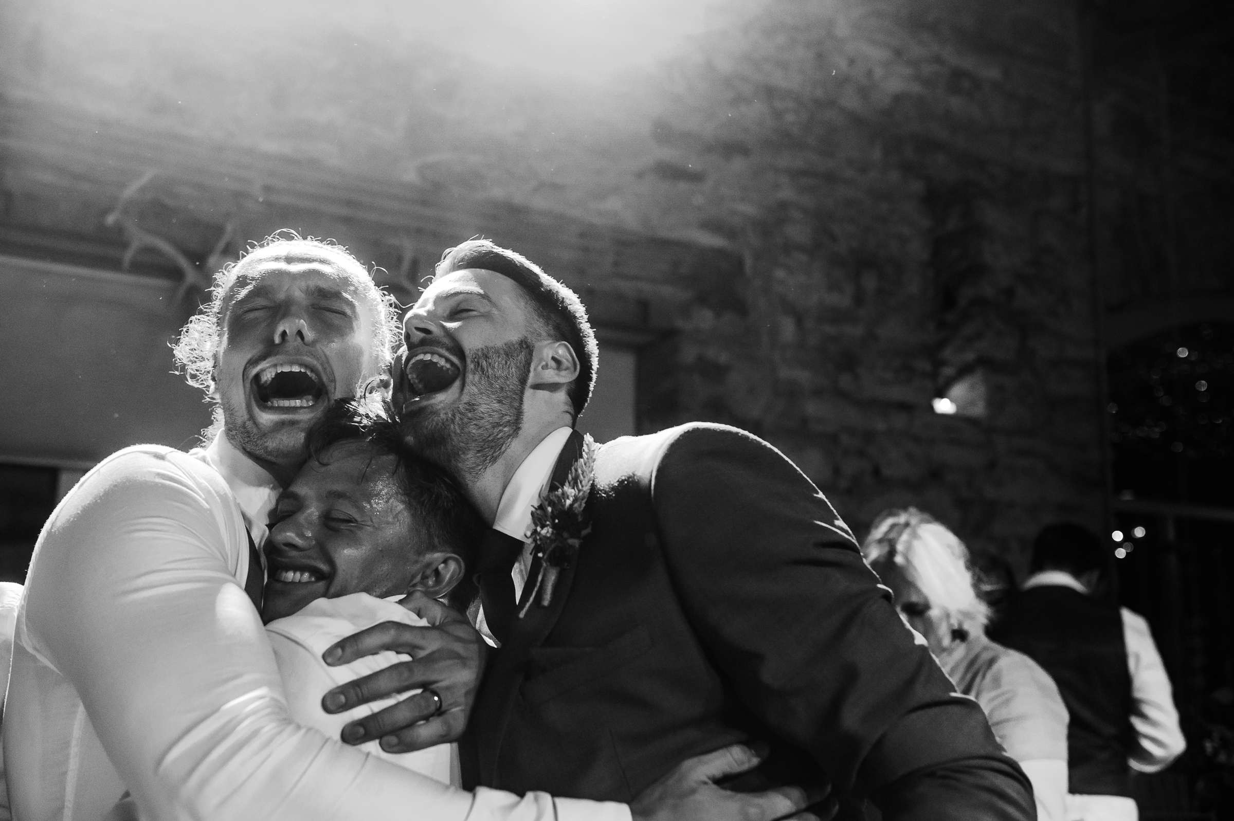 GUYS HUGGING AT A WEDDING